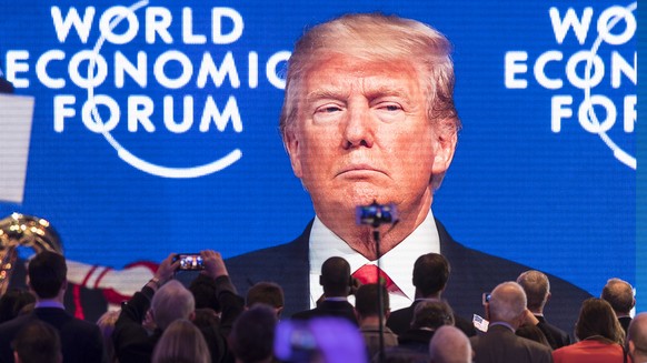 Participants watch the appearance of Donald Trump, President of the United States of America, on screen from an adjacent room, during the 48th Annual Meeting of the World Economic Forum, WEF, in Davos ...