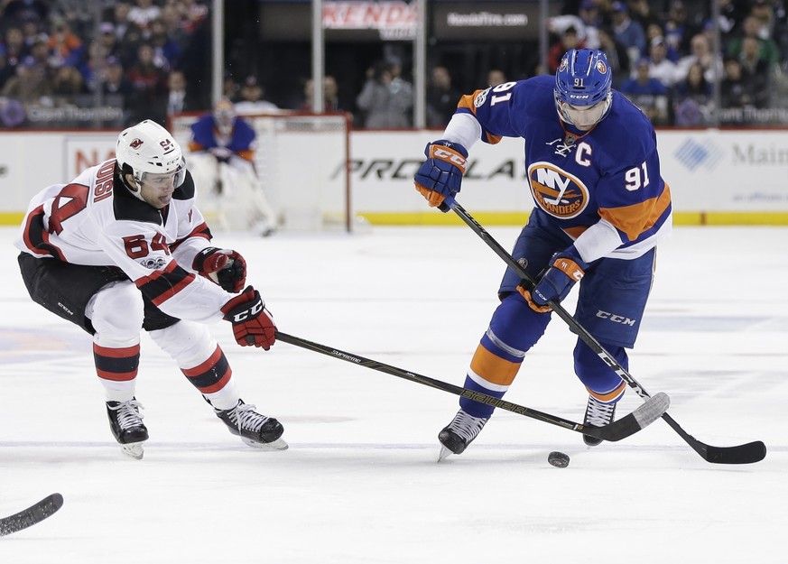 New Jersey Devils&#039; Joseph Blandisi (64) and New York Islanders&#039; John Tavares (91) fight for the puck during the second period of an NHL hockey game Friday, March 31, 2017, in New York. (AP P ...