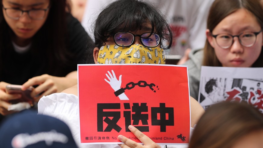 epa07642562 Protestors shout slogans and display placards during a protest to support Hong Kong protesters who are against the amendments to an extradition bill, in Taipei, Taiwan, 12 June 2019. The b ...