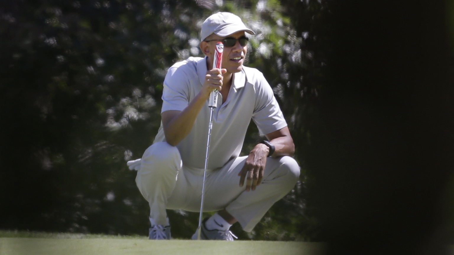 President Barack Obama holds a golf club as he squats down near a green while golfing Saturday, Aug. 8, 2015, at Farm Neck Golf Club, in Oak Bluffs, Mass., on the island of Martha&#039;s Vineyard. Oba ...